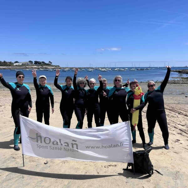 Groupe de longeurs derrière la banderole hoalan plantée dans le sable